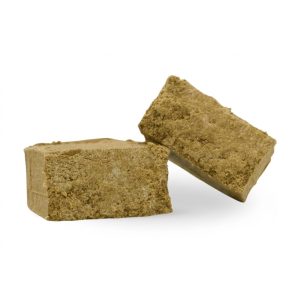 Lys Marok THCa hash i to lyse, kompakte stykker med tør og ensartet pollenstruktur på lys baggrund.