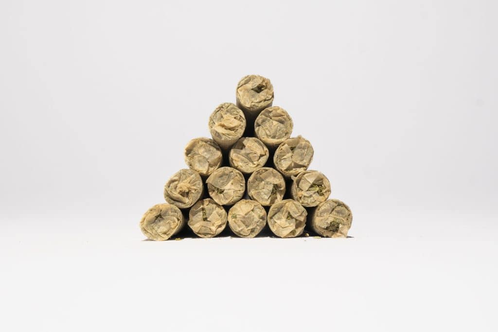 THCa pre-rolls stablet i pyramideform med synlige papirspidser og diskret urtefyld på hvid baggrund.